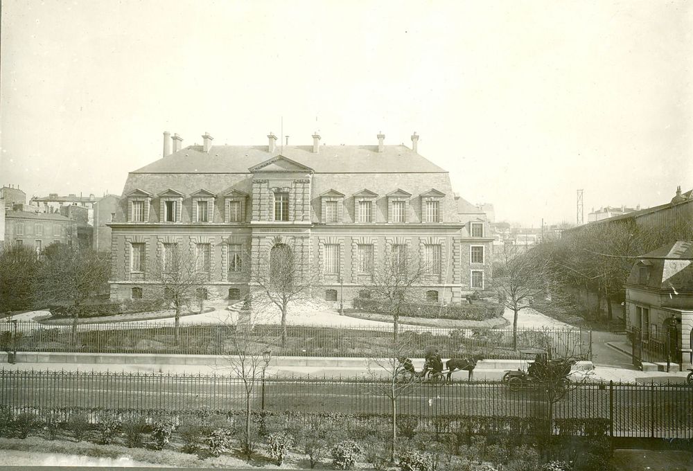  Façade du bâtiment historique de Institut Pasteur vers 1900-1910. Une calèche à cheval et une voiture dans la rue du docteur Roux.